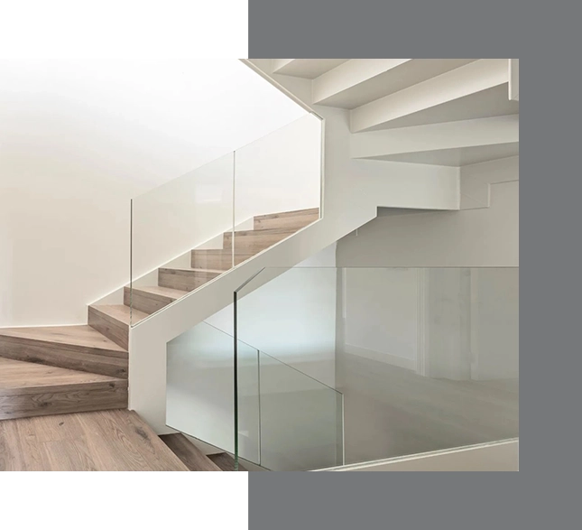 Modern staircase with wooden steps, white under-stair storage, and clear glass railings in a minimalist interior, perfect for real estate guide highlights.